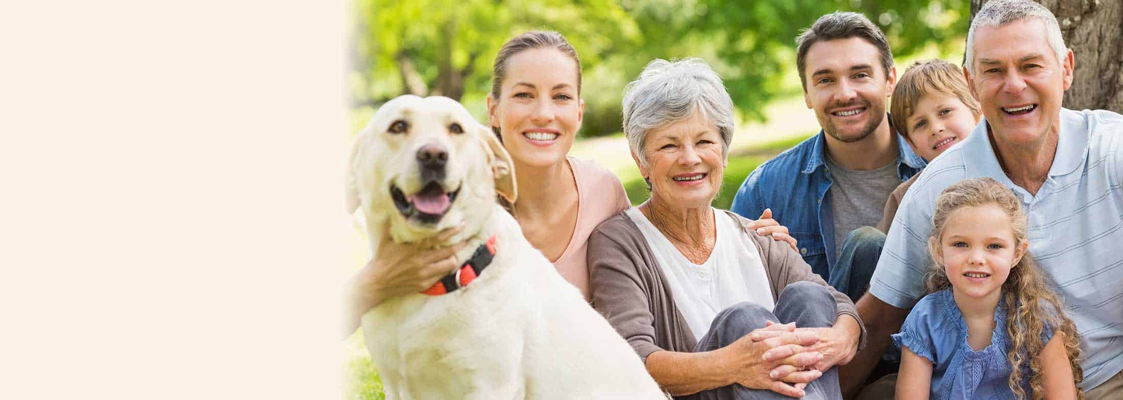 Family with dog smiling towards camera